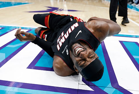 Miami Heat center Bam Adebayo (13) lies on the court during the first half of an NBA play-in tournament basketball game against the Charlotte Hornets in Charlotte, North Carolina.