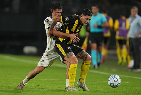 Franco Escobar of Uruguay's Peñarol protects the ball from Franco Zapiola of Argentina's Platense during a Copa Libertadores Group E soccer match in Montevideo, Uruguay.