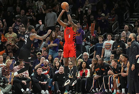 Portland Trail Blazers forward Jerami Grant (9) shoots a 3-pointer over Phoenix Suns guard Jalen Green (4) during the second half of an NBA play-in tournament basketball game, in Phoenix. 
