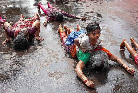 Devotees perform the Dondi ritual by lying prostrate along the road to reach a shrine on the occasion of Shitala Puja, in the Kalighat area, in Kolkata.