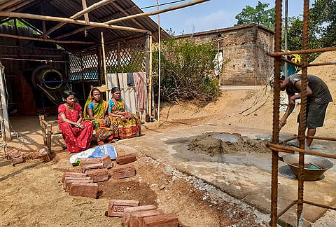 Bidu Singh, centre, a victim of the 2009 Lalgarh Maoist violence, sits with family members outside her house in Bandhgora village, in Lalgarh, Jhargram district, West Bengal.