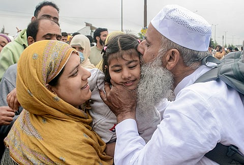 A pilgrim embraces a child as the first batch of Hajj pilgrims leave for Mecca, Saudi Arabia, at Hajj House, in Srinagar, Jammu and Kashmir.