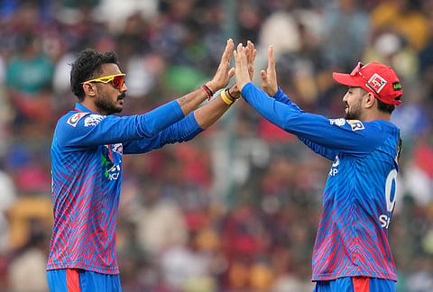 Delhi Capitals' captain Axar Patel, left, celebrates the dismissal of Royal Challengers Bengaluru's Tim David with a teammate during the Indian Premier League cricket match between Royal Challengers Bengaluru and Delhi Capitals in Bengaluru.