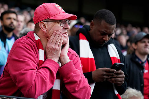 Arsenal supporters watch during the English Premier League soccer match between Manchester City and and Arsenal, in Manchester, England.