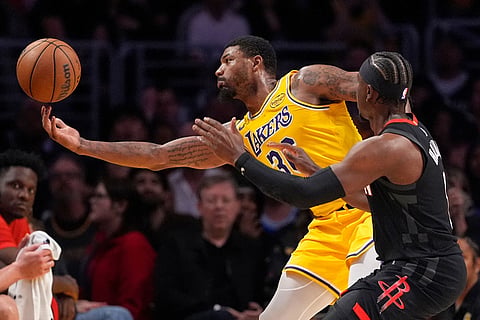 Los Angeles Lakers guard Marcus Smart, left, reaches for a loose ball along with Houston Rockets guard Aaron Holiday during the second half in Game 1 of a first-round NBA playoffs basketball series in Los Angeles.