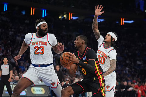 Atlanta Hawks' Jonathan Kuminga (0) drives past New York Knicks' Mitchell Robinson (23) and Jordan Clarkson (00) during the second half in Game 1 of a first-round NBA playoffs basketball series in New York.