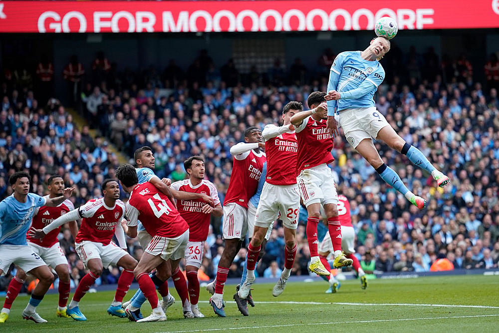 | Photo: AP/Dave Thompson : Manchester City's Erling Haaland heads the ball during the English Premier League soccer match between Manchester City and and Arsenal, in Manchester, England.