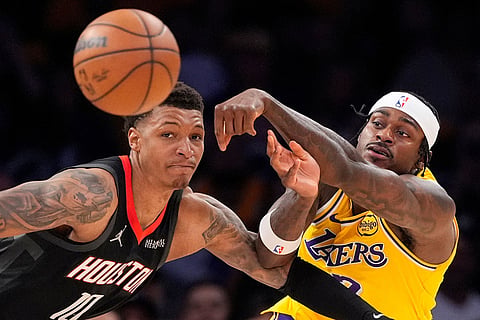 Los Angeles Lakers forward Jarred Vanderbilt, right, passes the ball while under pressure from Houston Rockets forward Jabari Smith Jr. during the second half in Game 1 of a first-round NBA playoffs basketball series in Los Angeles.