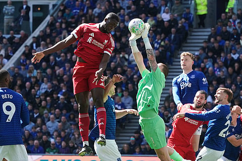 Liverpool's Ibrahima Konate, top, and Everton's goalkeeper Jordan Pickford compete for the ball during the English Premier League soccer match between Everton and Liverpool in Liverpool, England.