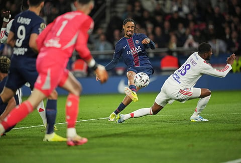 PSG's Bradley Barcola, centre, shoots the ball during the French League One soccer match between Paris Saint-Germain and Olympique Lyon in Paris, France.