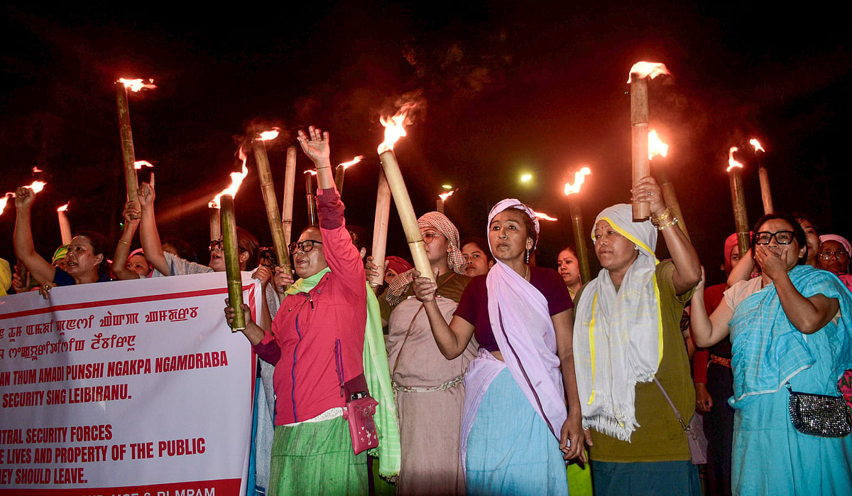Women hold torches during a rally to protest against the recent bomb attack in which two children were killed, at Singjamei, in Imphal, Manipur - PTI