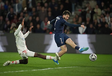 PSG's Khvicha Kvaratskhelia, right, and Lyon's Clinton Mata challenge for the ball during the French League One soccer match between Paris Saint-Germain and Olympique Lyon in Paris, France.