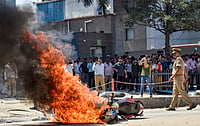 Source:  PTI : Flames billow as a police bike is set ablaze by factory workers during a protest demanding a hike in wages, in Noida, Gautam Buddh Nagar district, Uttar Pradesh, Monday, April 13, 2026. The protest carried incidents of arson, vandalism and stone-pelting reported from Phase-2 and Sector 60 areas, police said.