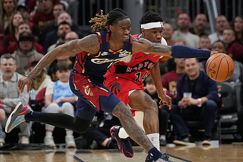 Cleveland Cavaliers guard Keon Ellis, left, reaches for the ball in front of Toronto Raptors guard Ja'kobe Walter (14) in the second half in Game 2 of a first-round NBA basketball playoffs series in Cleveland.