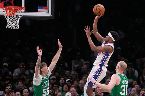 Philadelphia 76ers guard Vj Edgecombe takes a shot against Boston Celtics guard Baylor Scheierman (55) and forward Sam Hauser (30) during the first half of Game 2 of a first-round NBA playoffs basketball series in Boston.