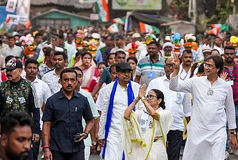 West Bengal Chief Minister Mamata Banerjee greets supporters during a roadshow as she campaigns in support of TMC candidates, at Shibpur constituency on the eve of the state Assembly elections, in Howrah district.