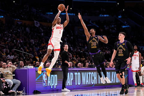 Houston Rockets guard Amen Thompson, left, shoots as Los Angeles Lakers guard Marcus Smart, center, defends during the first half in Game 2 of a first-round NBA playoffs basketball series in Los Angeles.