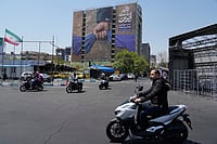 AP  : Motorbikes drive past a billboard that shows a graphic depicting a military personnel's hand holding the Strait of Hormuz in his fist with signs which read in Farsi: "In Iran's hands forever," "Trump couldn't do a damn thing," "The control of Strait of Hormuz will be Iran's forever," in Vanak Square in northern Tehran, Iran, Thursday, April 16, 2026. 