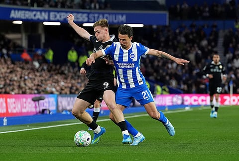 Chelsea's Liam Delap, left, and Brighton and Hove Albion's Olivier Boscagli battle for the ball during the English Premier League soccer match between Brighton & Hove Albion and Chelsea in Brighton, England.