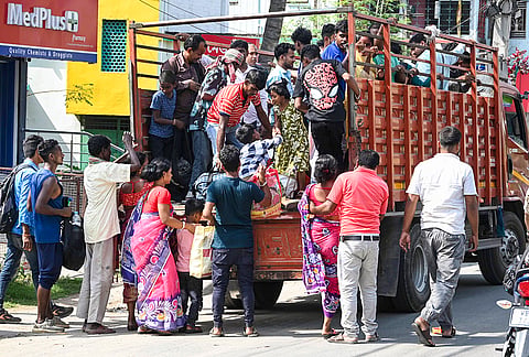 People board a truck as they leave for their hometowns on the eve of voting for the first phase of the West Bengal Assembly elections, at Raiganj, in Uttar Dinajpur district.