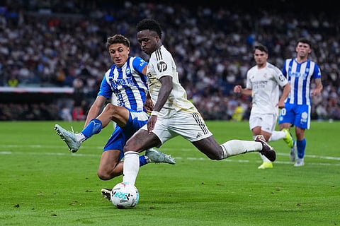 Alaves' Nahuel Tenaglia tries to block Real Madrid's Vinicius Junior during a La Liga soccer match between Real Madrid and Alaves in Madrid, Spain.