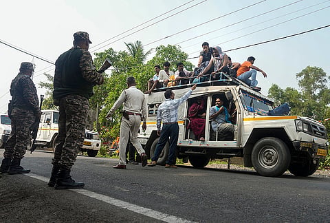 Security personnel along with election officials check the IDs of migrant workers at a checkpoint, ahead of the West Bengal Assembly elections, at Nandigram, Purba Medinipur district.