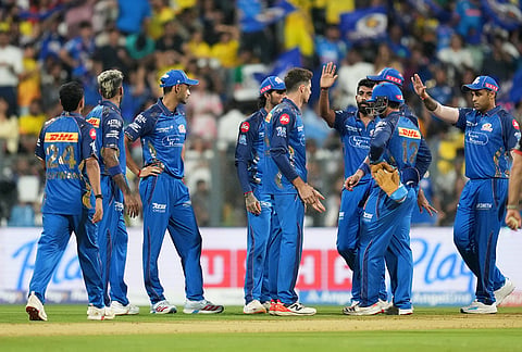 Mumbai Indians' Mitchell Santner, centre, celebrates with teammates the wicket of Chennai Super Kings' Sarfaraz Khan during the Indian Premier League cricket match between Mumbai Indians and Chennai Super Kings in Mumbai.