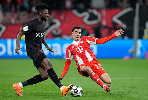 Leverkusen's Edmond Tapsoba, left, and Bayern's Jamal Musiala challenge for the ball during the German Soccer Cup semifinal match between Bayer Leverkusen and Bayern Munich in Leverkusen, Germany.
