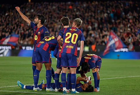 Barcelona's Lamine Yamal lies on the pitch in pain during the Spanish La Liga soccer match between Barcelona and Celta Vigo in Barcelona, Spain.