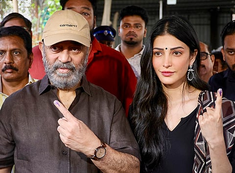 Actors Kamal Haasan and Shruti Haasan show their ink-marked fingers after casting their votes in the Tamil Nadu Assembly elections, at a polling station in Chennai.