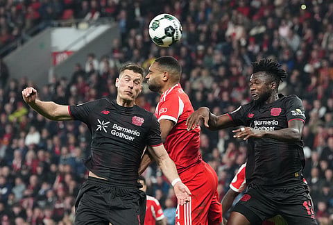 Leverkusen's Patrik Schick, from left, Bayern's Jonathan Tah and Leverkusen's Edmond Tapsoba challenge for the ball during the German Soccer Cup semifinal match between Bayer Leverkusen and Bayern Munich in Leverkusen, Germany.