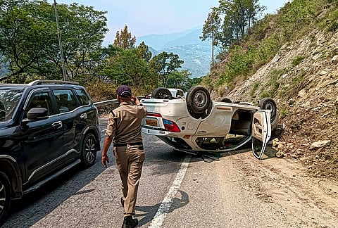 A police personnel at the site after a car overturned near Kuhed area on the Badrinath Highway, in Chamoli. According to police, the vehicle, carrying pilgrims from Haridwar to Badrinath Dham, allegedly went out of control, hit a hill and overturned, injuring five people including the driver. 