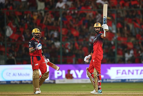 Royal Challengers Bengaluru's Devdutt Padikkal celebrates his fifty runs as batting partner Virat Kohli looks during the Indian Premier League cricket match between Royal Challengers Bengaluru and Gujarat Titans in Bengaluru.