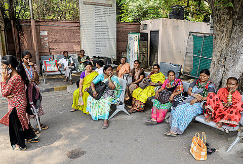 People wait for buses and private transport on the third day of the ongoing Telangana State Road Transport Corporation (TGSRTC) strike at Koti Bus Terminal, in Hyderabad.