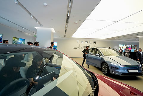 Visitors look at Tesla's Model Y L on display at the Tesla Experience Centre, Aerocity, in New Delhi.