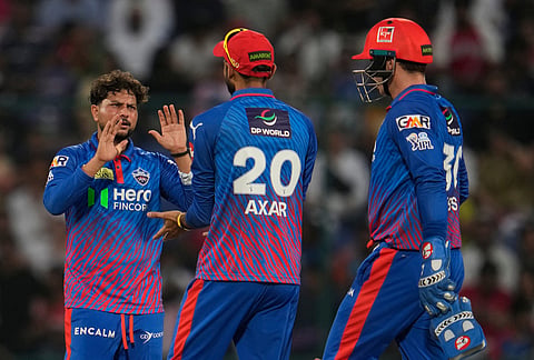 Delhi Capitals' Kuldeep Yadav, left, celebrates with captain Axar Patel the wicket of Punjab Kings' Prabhsimran Singh during the Indian Premier League cricket match between Delhi Capitals and Punjab Kings in New Delhi.