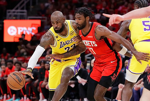 Los Angeles Lakers forward LeBron James, left, attempts to keep the ball as he drives around Houston Rockets forward Tari Eason during the first half in Game 3 of a first-round NBA playoffs basketball series in Houston.