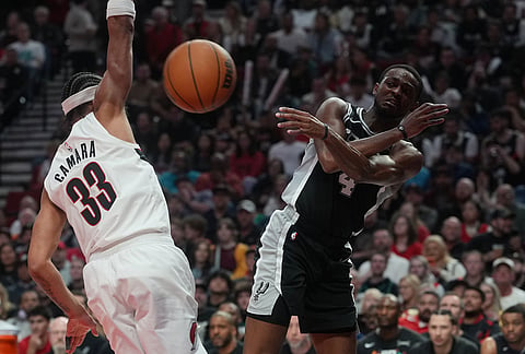 San Antonio Spurs guard De'aaron Fox (4) pass the ball past Portland Trail Blazers forward Toumani Camara (33) during the second half in Game 3 of a first-round NBA playoffs basketball series in Portland, Oregon.