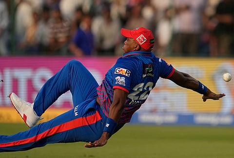 Delhi Capitals' Lungi Ngidi loses his balance while attempting to take a catch during the Indian Premier League cricket match between Delhi Capitals and Punjab Kings in New Delhi.