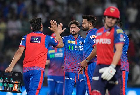 Delhi Capitals' Kuldeep Yadav, centre, celebrates with teammates the wicket of Punjab Kings' Cooper Connolly, right, walks during the Indian Premier League cricket match between Delhi Capitals and Punjab Kings in New Delhi.