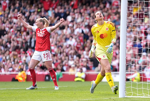 OL Lyonnes' goalkeeper Christiane Endler, right, reacts as Arsenal's Stina Blackstenius, left, celebrates her side's first goal during the Women's Champions League semi-final, first leg soccer match between Arsenal and OL Lyonnes in London, England.