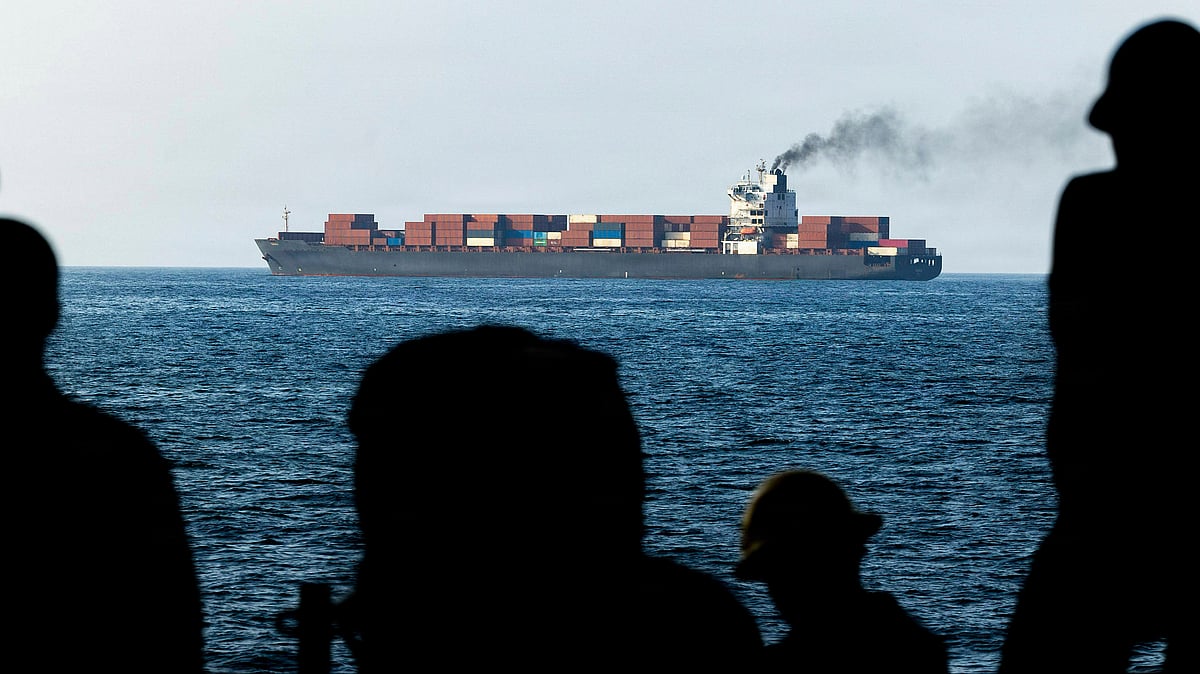 U.S. Navy sailors aboard the San Antonio-class amphibious transport dock ship USS New Orleans look toward the Iranian cargo vessel M V Touska after it was boarded and fired upon for violating the maritime blockade against ships entering or exiting Iranian ports and coastal areas, April 21, 2026, on the Gulf of Oman. - null