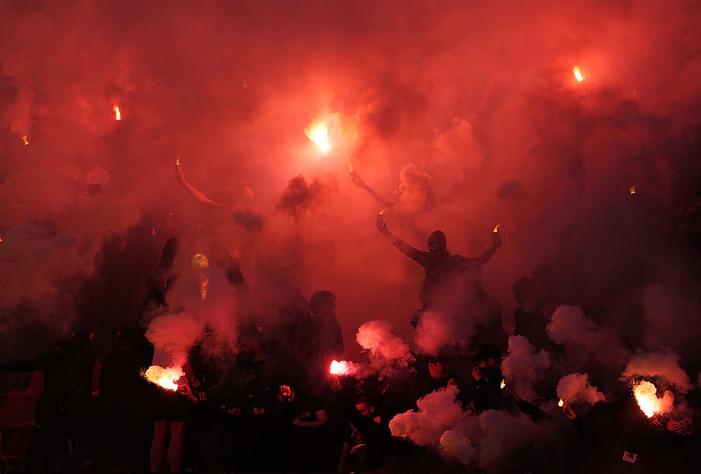 Partizan fans light fireworks during a Serbian National soccer league derby match between Red Star and Partizan in Belgrade, Serbia.
 - | Photo: AP/Darko Vojinovic 