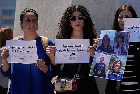 Journalists hold placards and a poster that show portraits of Lebanese journalist Amal Khalil who was killed on Wednesday in an Israeli airstrike along with other journalists, during a sit-in in Beirut, Lebanon, Thursday, April 23, 2026. The Arabic placard centre reads:"Give the authority for the International Criminal Court now." 