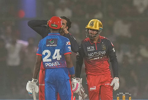 Delhi Capitals' Abishek Porel being assisted by Royal Challengers Bengaluru's Venkatesh Iyer and Jitesh Sharma amid a dust storm during the Indian Premier League (IPL) T20 cricket match between Delhi Capitals and Royal Challengers Bengaluru, in New Delhi.