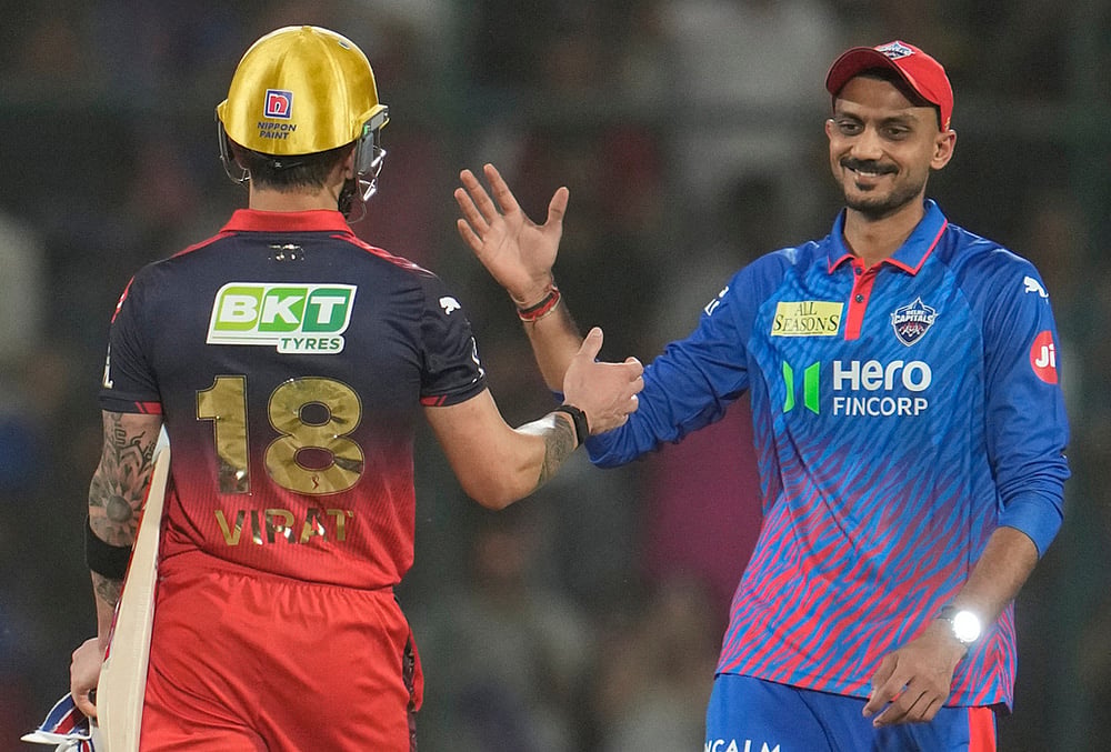 | Photo: AP/Manish Swarup : Delhi Capitals' captain Axar Patel, right, shake hands with Royal Challengers Bengaluru's Virat Kohli after Royal Challengers Bengaluru won the match during the Indian Premier League cricket match between Delhi Capitals and Royal Challengers Bengaluru in Delhi.
