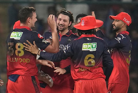 Royal Challengers Bengaluru's Josh Hazlewood, left, celebrate with teammates the wicket of Delhi Capitals' Nitish Rana during the Indian Premier League cricket match between Delhi Capitals and Royal Challengers Bengaluru in Delhi.