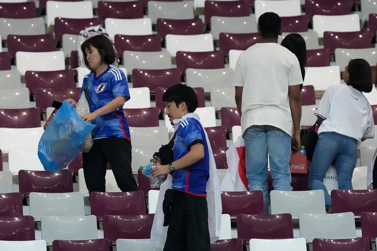 Japanese fans clean up a stadium post an international match. - AP