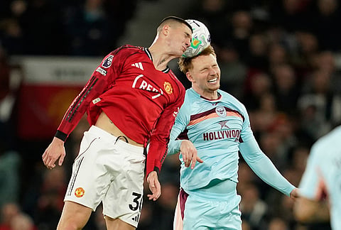 Manchester United's Benjamin Sesko, left, and Brentford's Sepp van den Berg jump for the ball during the Premier League soccer match between Manchester United and Brentford in Manchester, England.