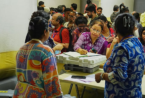 Polling officials collect Electronic Voting Machine (EVM) and Voter Verifiable Paper Audit Trail (VVPAT) units at a distribution centre on the eve of second phase of voting in the West Bengal Assembly elections, in Kolkata.
